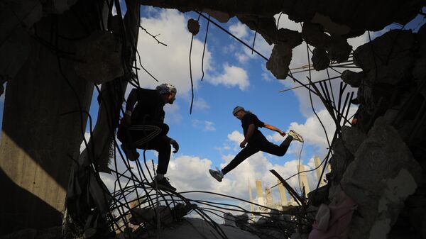 2025 оны 10-р сарын 13-нд Газын Газа хотод гал зогсоосны дараа Палестины залуу тамирчид аль-Муграка дахь сүйрсэн барилгуудын балгас дунд паркур хийж байна. - Sputnik Монгол Улс