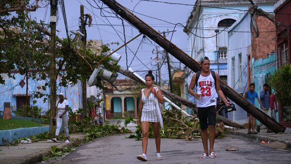 Мелисса хар салхинд өртсөн Кубын Сантьяго де Куба хотын гудамжаар явган зорчигчид алхаж байна. - Sputnik Монгол Улс