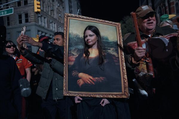 2025 оны 10-р сарын 31-ний Баасан гарагт Нью-Йорк хотод болсон Тосгоны Хэллоуины жагсаалын үеэр нэгэн хүн зураг авахаар түр зогсож байна. (AP Photo/Andres Kudacki) 2025 оны 10-р сарын 31-ний Баасан гарагт Нью-Йорк хотод болсон Тосгоны Хэллоуины жагсаалын үеэр нэгэн хүн зураг авахаар түр зогсож байна. (AP Photo/Andres Kudacki) - Sputnik Монгол Улс