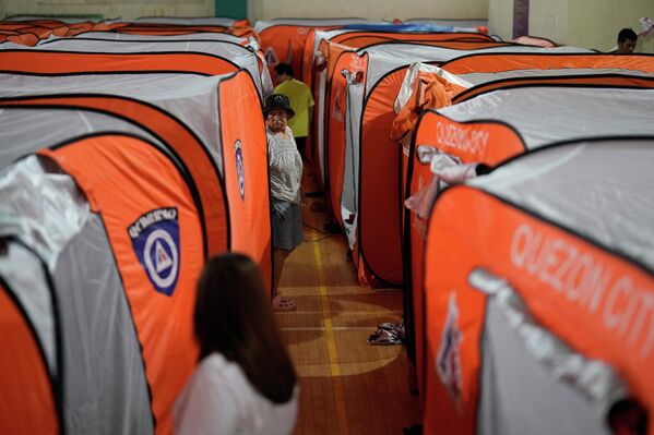 2025 оны 11-р сарын 9-ний ням гарагт Филиппиний Кесон хотод Фунг-вонг хар салхи тус улсад нэвтэрч байх үед нэгэн эмэгтэй нүүлгэн шилжүүлэх төвийн майхны хажууд алхаж байна. (AP Photo/Aaron Favila) 2025 оны 11-р сарын 9-ний ням гарагт Филиппиний Кесон хотод Фунг-вонг хар салхи тус улсад нэвтэрч байх үед нэгэн эмэгтэй нүүлгэн шилжүүлэх төвийн майхны хажууд алхаж байна. (AP Photo/Aaron Favila) - Sputnik Монгол Улс