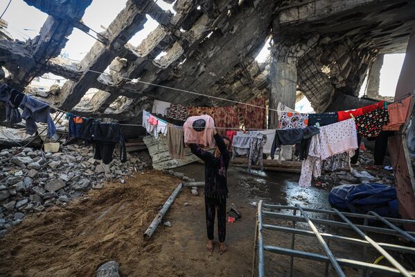 ГАЗА ХОТ, ГАЗА 11-Р САРЫН 10: Палестинчууд 2025 оны 11-р сарын 10-нд Газын зүүн хэсэгт орших Шужайя хороололд Израилийн дайралтад өртөж сүйрсэн барилгуудын балгасны дунд амьдарч байна. (Зураг: Hamza Z. H. Qraiqea/Anadolu via Getty Images) - Sputnik Монгол Улс