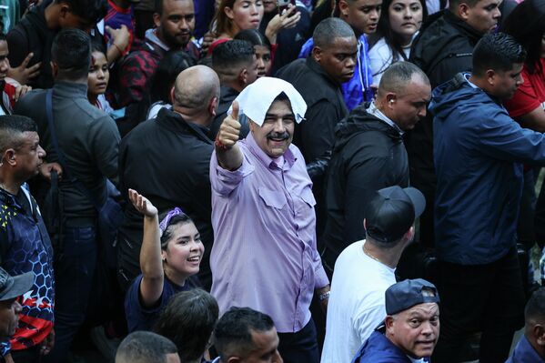 2025 оны 11-р сарын 13, Венесуэл, Каракас: Венесуэлийн Ерөнхийлөгч Николас Мадуро засгийн газрыг дэмжигч залуучуудын жагсаалын үеэр дэмжигчидтэйгээ мэндчилж байна. Зураг: Хесус Варгас/dpa (Зураг: Jesus Vargas/via Getty Images) - Sputnik Монгол Улс