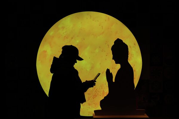 БЭЭЖИН, ХЯТАД (16/11, AP/Andy Wong): Худалдааны төвд сарны дэргэд Будда хэлбэртэй картонны өмнө нэгэн эмэгтэй утсаа үзэж байна. Энэ нь Бээжингийн орчин үеийн худалдаа, соёлын холимог дүр төрхийг харуулж байна. БЭЭЖИН, ХЯТАД (16/11, AP/Andy Wong): Худалдааны төвд сарны дэргэд Будда хэлбэртэй картонны өмнө нэгэн эмэгтэй утсаа үзэж байна. Энэ нь Бээжингийн орчин үеийн худалдаа, соёлын холимог дүр төрхийг харуулж байна. - Sputnik Монгол Улс