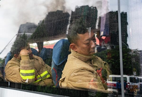 Хонконгийн Тай По дүүргийн Ван Фук Корт хороололд гарсан галыг унтраахад ээлжээр ажиллаж байсан гал сөнөөгчид богино амралт авч байна. 11-р сарын 26-нд гарсан түймэрт дор хаяж 44 хүн нас барж, 45 хүн гэмтэж, аврах ажиллагаа үргэлжилж байна. (2025.11.27, зурагчин Хоу Ю / China News Service / VCG / Getty Images) - Sputnik Монгол Улс