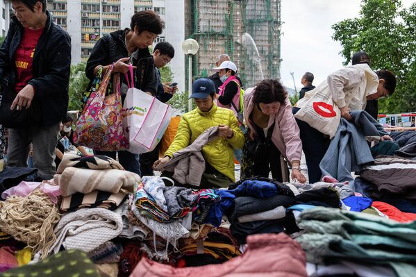 Гал гарсан Ван Фук Кортын ойролцоо оршин суугчид хандивын хувцас авч байна. (2025.11.27, AP/Чан Лон Хей) - Sputnik Монгол Улс