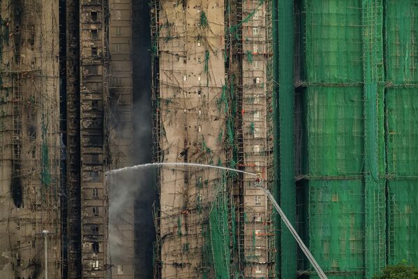 Хонконгийн Тай По дүүргийн Ван Фук Корт хороололд гарсан галыг унтраахад гал сөнөөгчид ажиллаж байна. (2025.11.27, AP/Чан Лон Хей) - Sputnik Монгол Улс