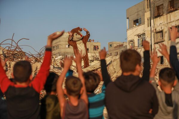 Газа хот, Газа — 2025 оны 11-р сарын 23. Палестины сайн дурын залуучууд Израилийн бөмбөгдөлтөд эвдрэн сүйдсэн Шати дүрвэгсдийн хуарангийн нуранги дунд цугларч, хүүхдүүдэд зориулсан хөгжөөнт арга хэмжээ зохион байгууллаа. Тэд хүүхдүүдийн нүүрийг будаж, олон төрлийн үзүүлбэр толилуулан тасралтгүй бөмбөгдөлтийн дунд өсч буй Палестины багачуудад баяр хөөр өгөхийг зорьжээ. (Зураг: Абдалхкем Абу Риаш / Анадуолу, Getty Images-ээр) - Sputnik Монгол Улс