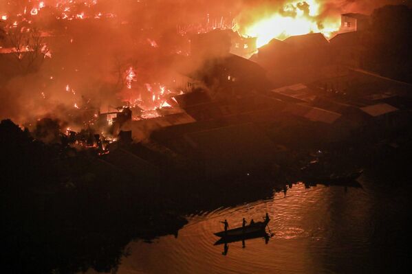 Бангладеш, Дакка — 2025 оны 11-р сарын 25-ны өдөр Корэйл хороололд гарсан хүчтэй гал мянга мянган гэрийг сүйтгэж, зузаан утаа тэнгэрт тогтов. Иргэд аюулгүй газар руу нүүхээр яарч байна. (Мд. Ракибул Хасан Рафиу /NurPhoto via Getty Images) - Sputnik Монгол Улс