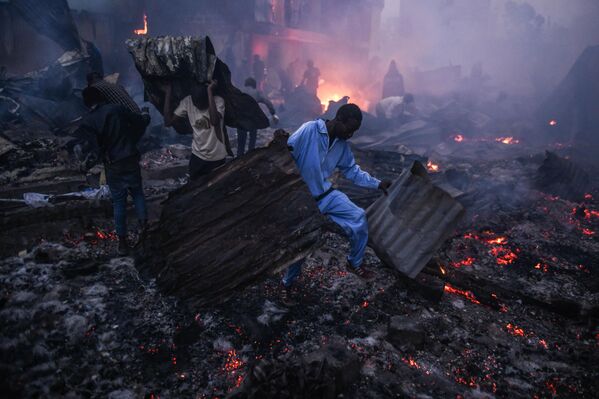 Кени, Найроби — 2025 оны 11-р сарын 20-ны өдөр Найроби хотын Мукуру Фуата Няё дүүрэгт өглөөний цагаар гарсан галын улмаас олон байшин шатаж сүйдсэн. Оршин суугчид эд зүйлсээ аврахыг оролдож байхад гал сөнөөгчид галыг хяналтандаа авч чаджээ. (Зураг: Жералд Андерсон/Anadolu via Getty Images) - Sputnik Монгол Улс