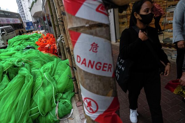 2025 оны 12-р сарын 4-ний Пүрэв гарагт Хонконгийн Шинэ Нутаг Дүүргийн Тай По дүүрэгт байрлах Ван Фук Кортод гарсан аймшигт галын дараа Куарри Бэй дүүрэгт явган зорчигчид шатны тор болон барилгын материалын хажуугаар өнгөрч байна. (AP Photo/Chan Long Hei) 2025 оны 12-р сарын 4-ний Пүрэв гарагт Хонконгийн Шинэ Нутаг Дүүргийн Тай По дүүрэгт байрлах Ван Фук Кортод гарсан аймшигт галын дараа Куарри Бэй дүүрэгт явган зорчигчид шатны тор болон барилгын материалын хажуугаар өнгөрч байна. (AP Photo/Chan Long Hei) - Sputnik Монгол Улс