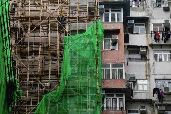 2025 оны 12-р сарын 4-ний Пүрэв гарагт Хонконгийн Шинэ Нутаг Дүүргийн Тай По дүүрэгт байрлах Ван Фук Кортод гарсан аймшигт галын дараа барилгын ажилчид Куарри Бэй дүүрэгт засварын төслийн шатны торыг буулгаж байна. (AP Photo/Chan Long Hei) 2025 оны 12-р сарын 4-ний Пүрэв гарагт Хонконгийн Шинэ Нутаг Дүүргийн Тай По дүүрэгт байрлах Ван Фук Кортод гарсан аймшигт галын дараа барилгын ажилчид Куарри Бэй дүүрэгт засварын төслийн шатны торыг буулгаж байна. (AP Photo/Chan Long Hei) - Sputnik Монгол Улс