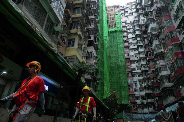 2025 оны 12-р сарын 4-ний Пүрэв гарагт Хонконгийн Шинэ нутаг дэвсгэрийн Тай По дүүрэгт байрлах Ван Фук Кортод гарсан аймшигт галын дараа Куарри Бэй дүүрэгт засвар хийгдэж буй барилгын хажуугаар барилгын ажилчид алхаж байна. (AP Photo/Chan Long Hei) 2025 оны 12-р сарын 4-ний Пүрэв гарагт Хонконгийн Шинэ нутаг дэвсгэрийн Тай По дүүрэгт байрлах Ван Фук Кортод гарсан аймшигт галын дараа Куарри Бэй дүүрэгт засвар хийгдэж буй барилгын хажуугаар барилгын ажилчид алхаж байна. (AP Photo/Chan Long Hei) - Sputnik Монгол Улс