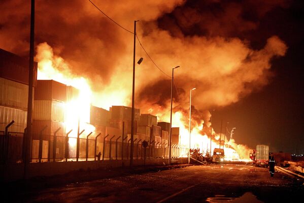 Иран, Бандар Абас - 4-р сарын 27: 2025 оны 4-р сарын 27-нд Ираны Хормозган мужийн Бандар Аббас хотын баруун өмнөд хэсэгт, Ираны Бандар Аббас хотын ойролцоо албаныхан үйл ажиллагаа явуулж байх үед Шахид Ражаи боомтод хүчтэй дэлбэрэлт болсны дараа гал гарч байна. 4-р сарын 27-нд болсон дэлбэрэлтийн улмаас дөчин гаруй хүн амиа алдаж, мянга гаруй хүн шархаджээ. (Зурагчин Хессам оддин Ансариан/Getty Images) - Sputnik Монгол Улс