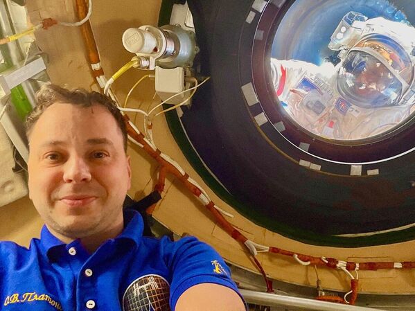 Сансрын нисгэгч Олег Платонов Олон улсын сансрын станц дээр селфи хийж байгаа бол түүний хамтрагчид Алексей Зубрицкий, Сергей Рыжиков нар гадаа ажиллаж байна. - Sputnik Монгол Улс