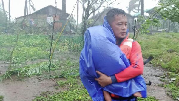 2025 оны 9-р сарын 22, Филиппиний хойд хэсэгт орших Кагаян мужийн Санта Ана хотод Рагаса супер хар салхины улмаас аврагч хүүхдийг аюулгүй газарт нүүлгэн шилжүүлж байна. - Sputnik Монгол Улс